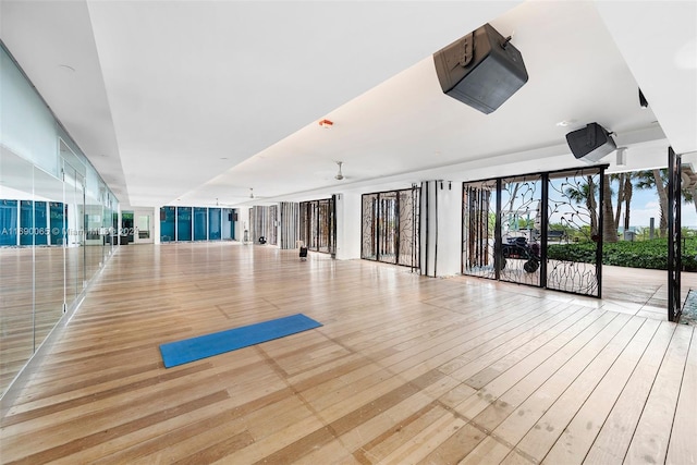 workout room featuring ceiling fan and light hardwood / wood-style floors