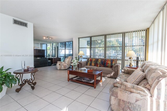 tiled living room featuring a wall of windows