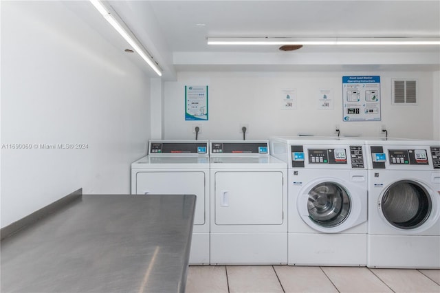 clothes washing area with light tile patterned floors and separate washer and dryer