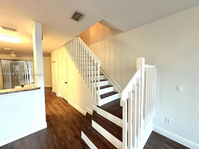 stairway with hardwood / wood-style floors