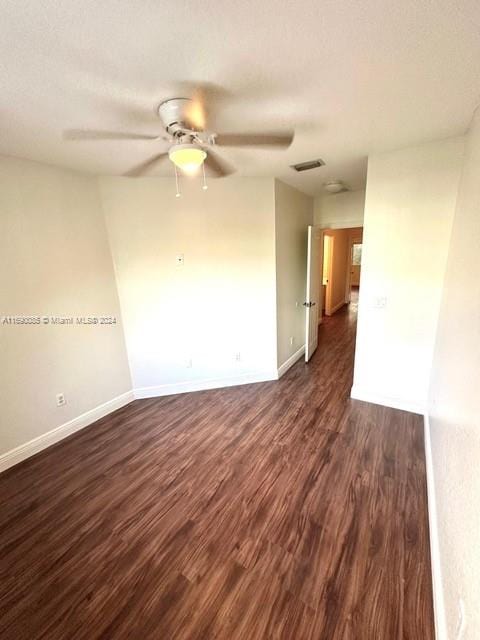 empty room with dark wood-type flooring and ceiling fan