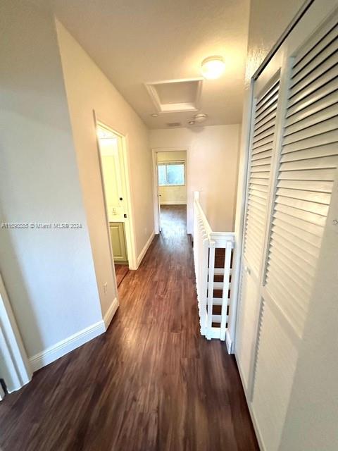 corridor with dark hardwood / wood-style flooring