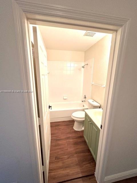 full bathroom featuring hardwood / wood-style flooring, vanity, toilet, and shower / bath combination