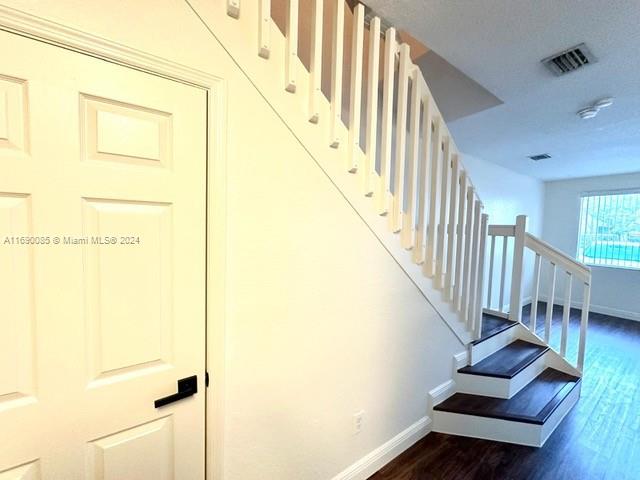 staircase with hardwood / wood-style flooring