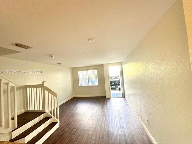 empty room featuring lofted ceiling and dark hardwood / wood-style flooring