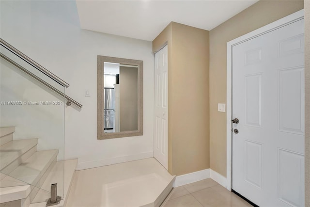 21300 San Simeon Way Unit K2, Miami, FL 33179 - entrance foyer featuring light tile patterned flooring, stairs, and baseboards