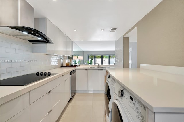 kitchen featuring black electric stovetop, dishwasher, light tile patterned floors, wall chimney range hood, and backsplash