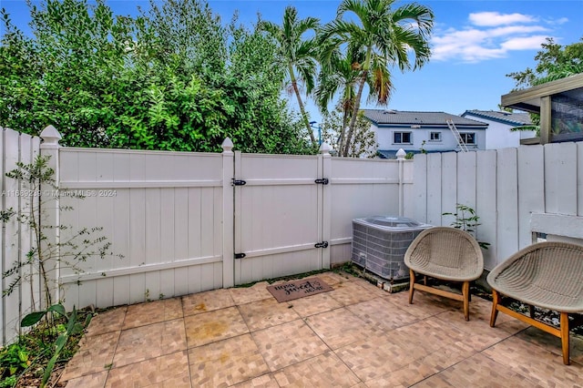21300 San Simeon Way Unit K2, Miami, FL 33179 - view of patio / terrace with a gate, central air condition unit, and a fenced backyard