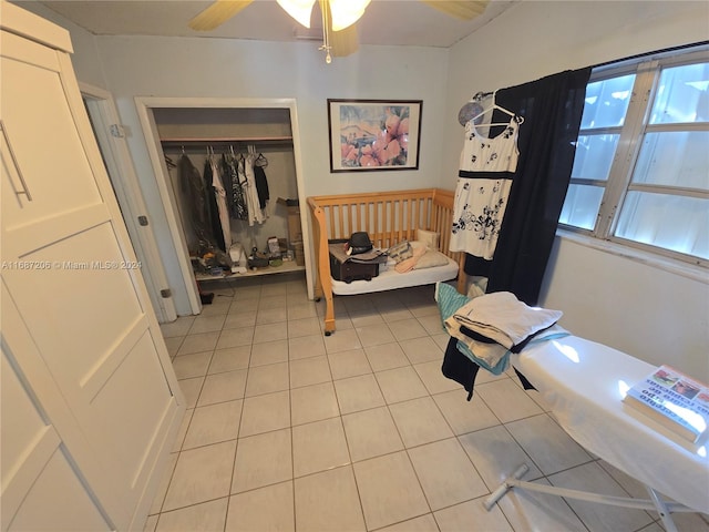 bedroom featuring light tile patterned floors, ceiling fan, and a closet