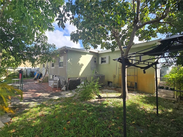 back of property with central air condition unit and a patio