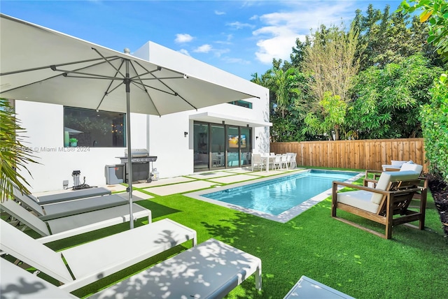 view of pool with a patio area, a yard, and area for grilling