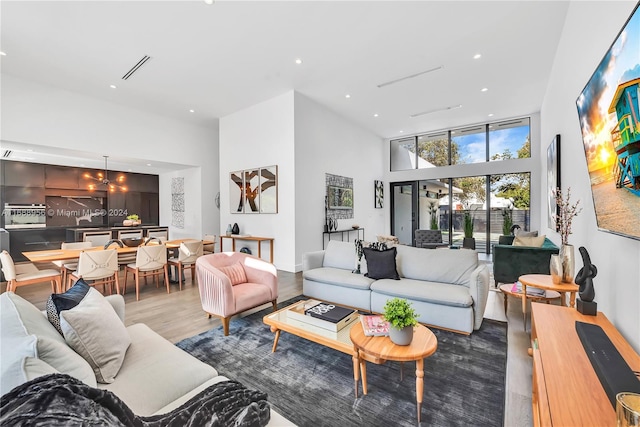 living room featuring hardwood / wood-style flooring and a towering ceiling