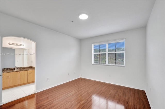 spare room with light wood-type flooring and sink