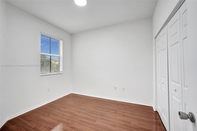 unfurnished bedroom with a closet and wood-type flooring