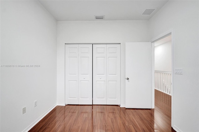 unfurnished bedroom with hardwood / wood-style flooring and a closet