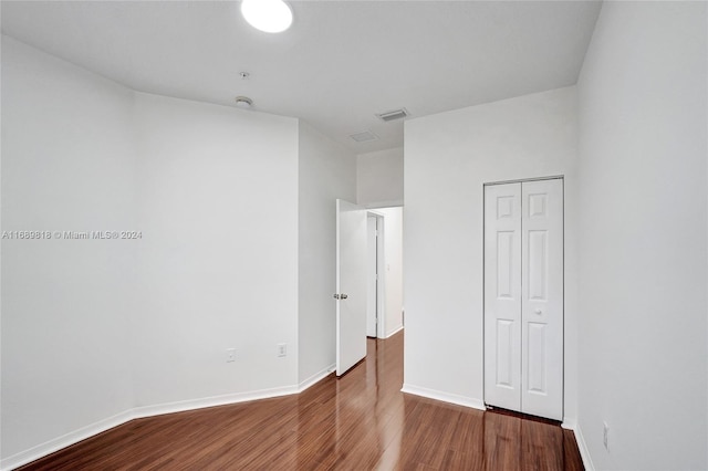 unfurnished bedroom featuring hardwood / wood-style flooring and a closet