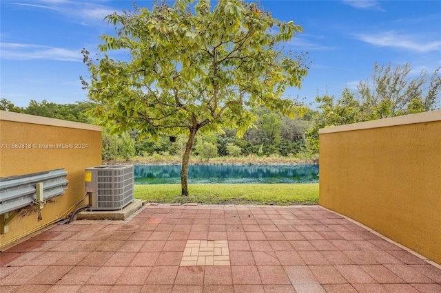 view of patio with a water view and central AC