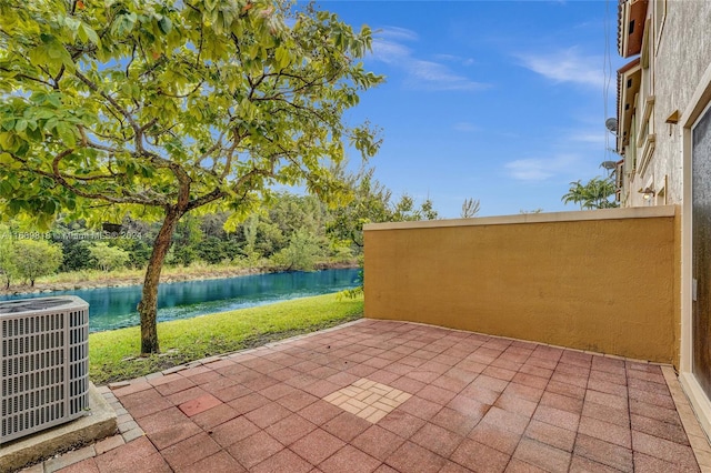 view of patio with a water view and cooling unit