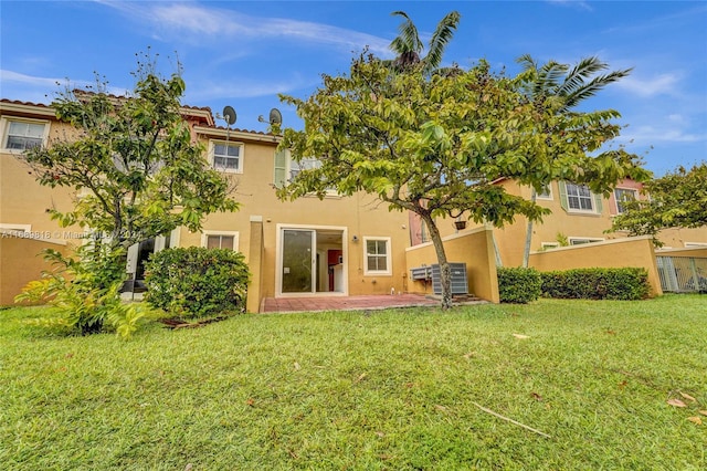 back of property with a patio area and a yard