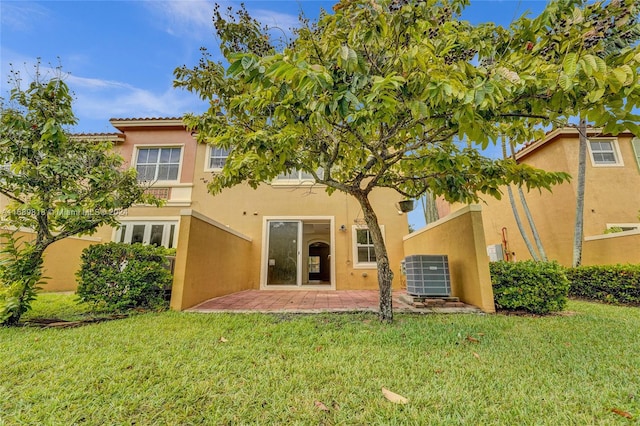 rear view of property featuring a patio, central AC unit, and a yard