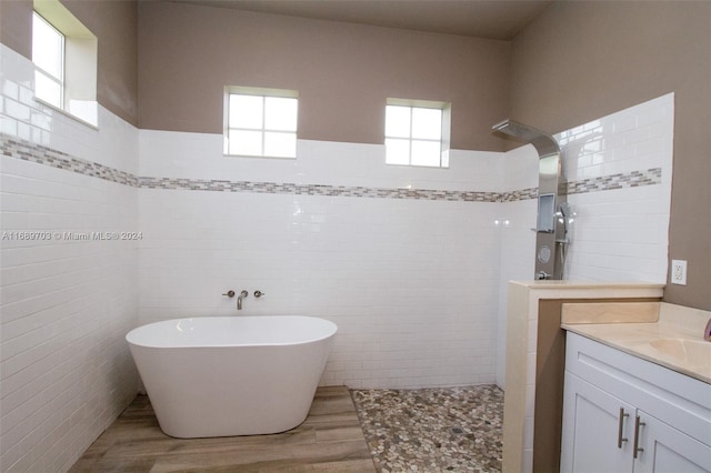 bathroom featuring vanity, separate shower and tub, and tile walls