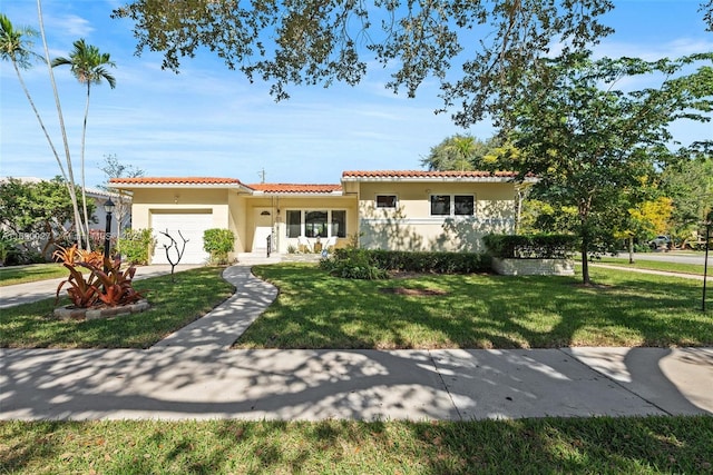 mediterranean / spanish house with a front lawn and a garage