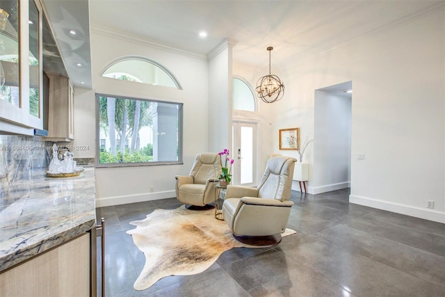 living area featuring a notable chandelier, ornamental molding, a towering ceiling, and french doors