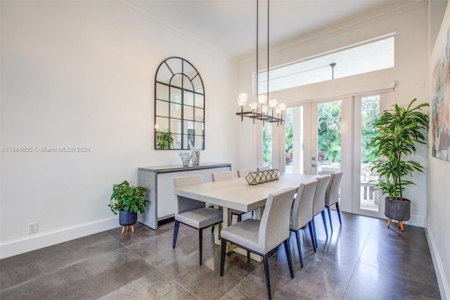 dining room with a chandelier, ornamental molding, and french doors