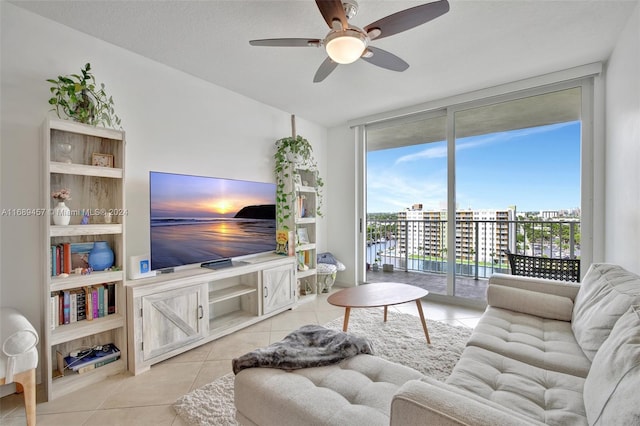 living room featuring light tile patterned flooring, ceiling fan, and a textured ceiling