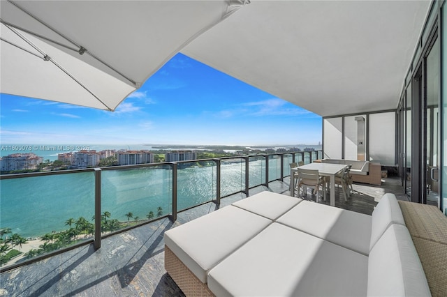 balcony featuring a water view and an outdoor living space