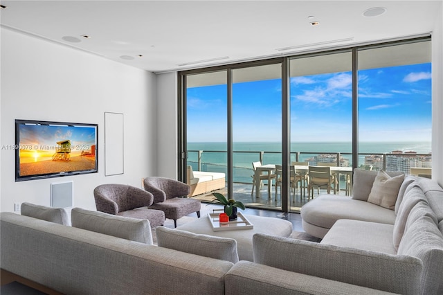 living room featuring a water view and a wall of windows