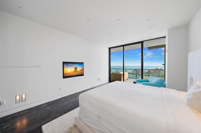 bedroom with a water view, a wall of windows, and access to outside