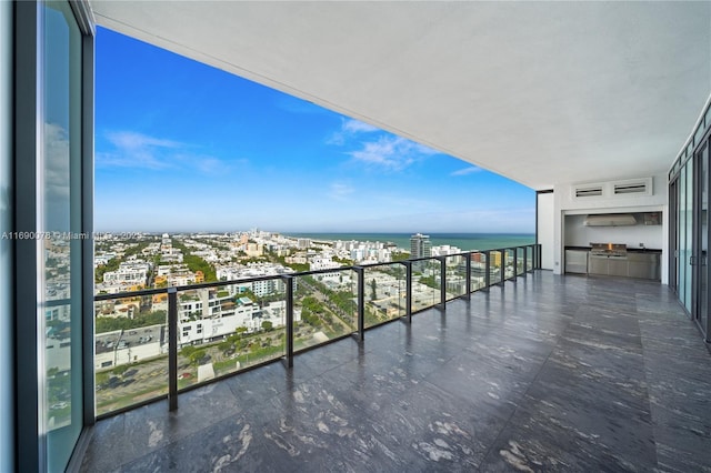 balcony featuring a water view and an outdoor kitchen