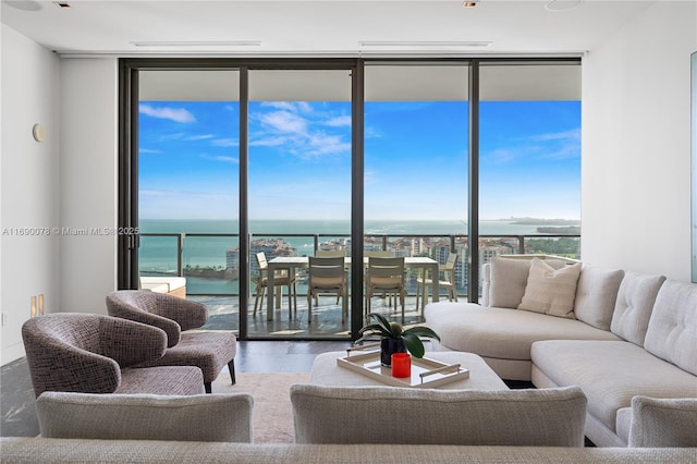 living room with hardwood / wood-style floors, a wall of windows, and a water view