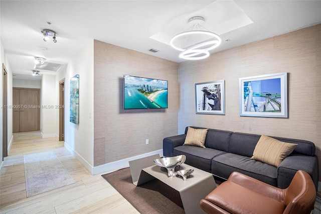 living room with a chandelier and light hardwood / wood-style flooring