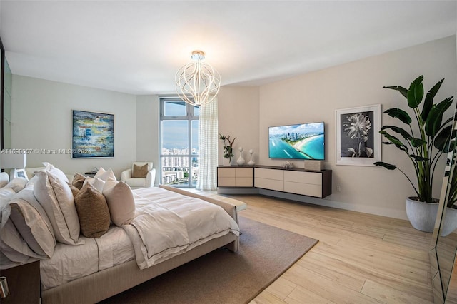 bedroom featuring a chandelier and light wood-type flooring