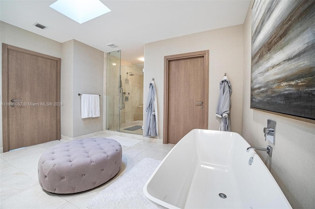 bathroom featuring a skylight, tile patterned flooring, and independent shower and bath