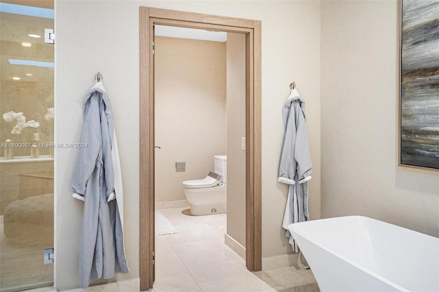 bathroom with a washtub, tile patterned flooring, and toilet