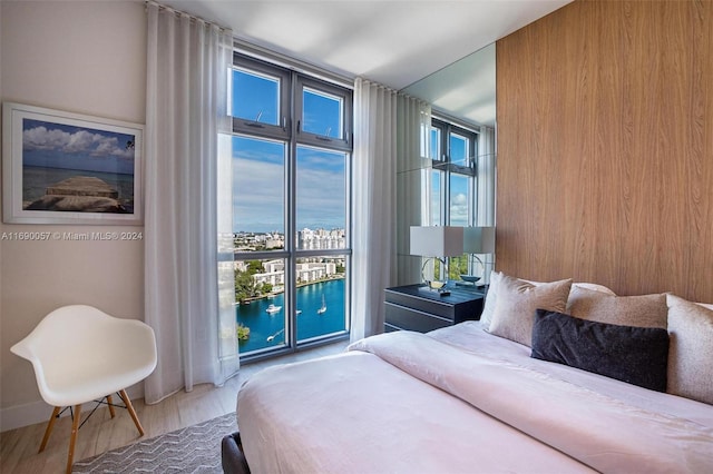 bedroom with wood-type flooring and a water view