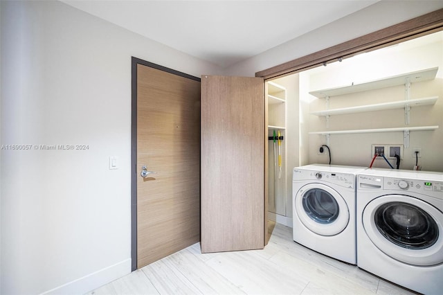 clothes washing area with light hardwood / wood-style flooring and washing machine and clothes dryer