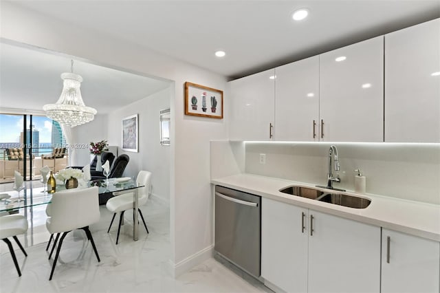 kitchen with stainless steel dishwasher, sink, pendant lighting, an inviting chandelier, and white cabinetry