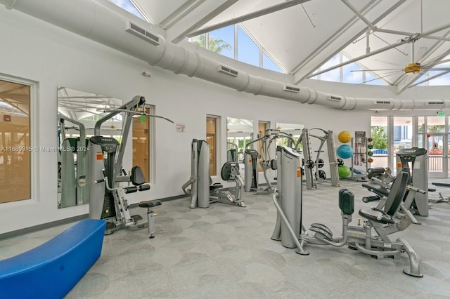 gym featuring light carpet and high vaulted ceiling