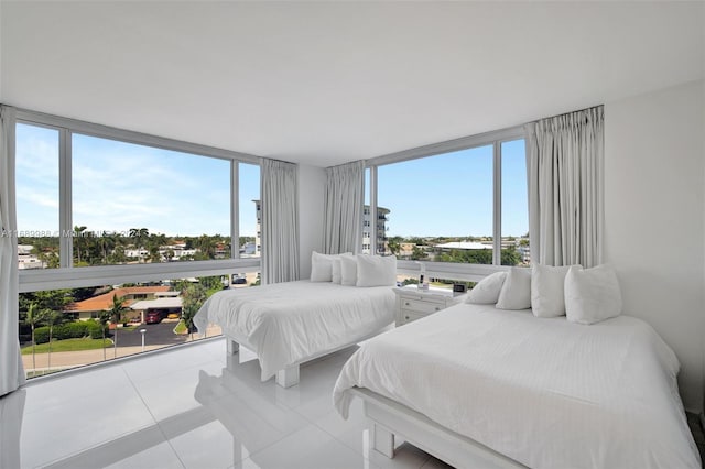 bedroom with expansive windows and light tile patterned flooring