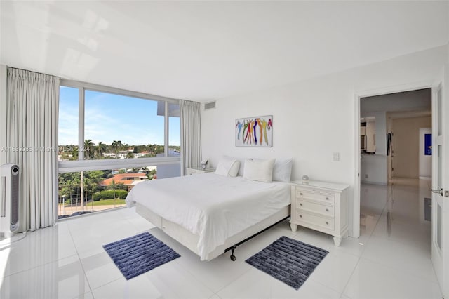 bedroom with expansive windows and light tile patterned floors