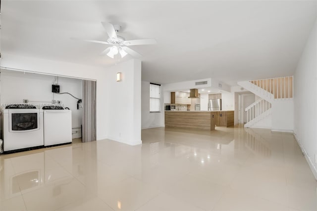 unfurnished living room with light tile patterned flooring, ceiling fan, and separate washer and dryer