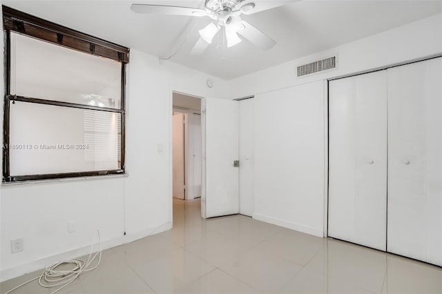 unfurnished bedroom featuring light tile patterned flooring and ceiling fan