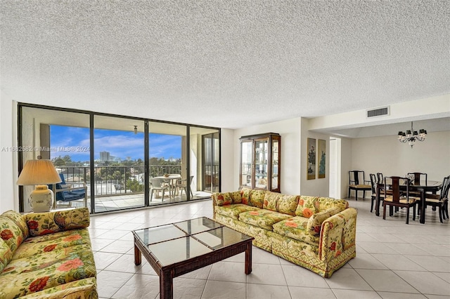 tiled living room featuring a wall of windows, a textured ceiling, and an inviting chandelier