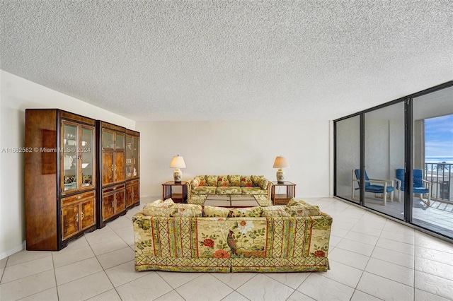 living room featuring a textured ceiling, light tile patterned floors, and floor to ceiling windows