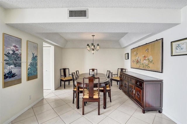 tiled dining area featuring a chandelier and a textured ceiling