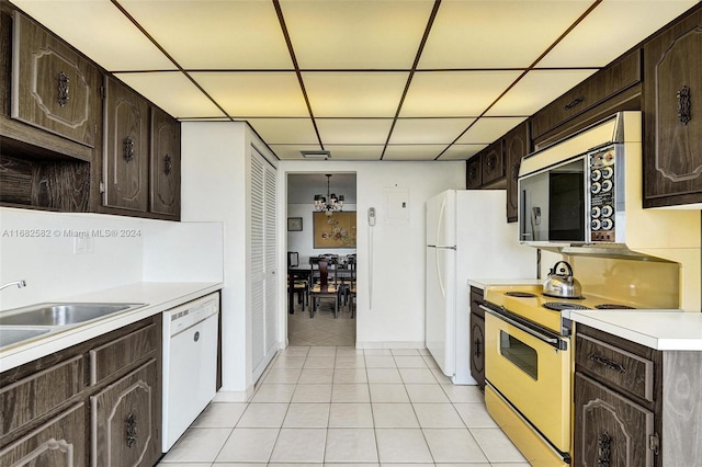 kitchen featuring white appliances, dark brown cabinets, and a drop ceiling